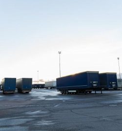transportation, freight transport and vehicle concept - trucks and trailers on parking